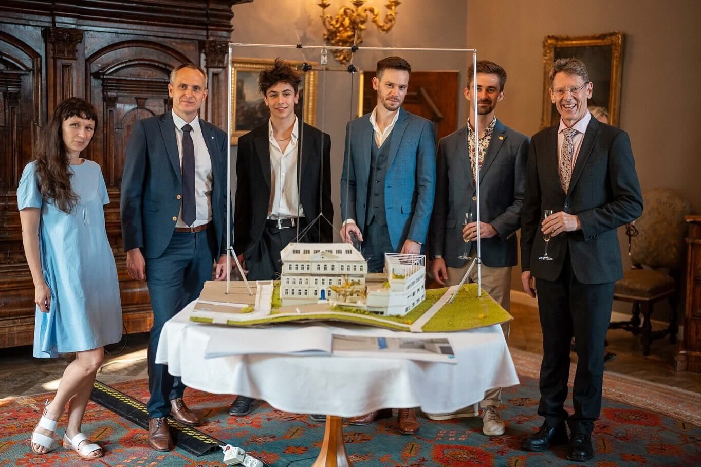 Ariya with his headmaster and three architecture alumni behind his moving floor model